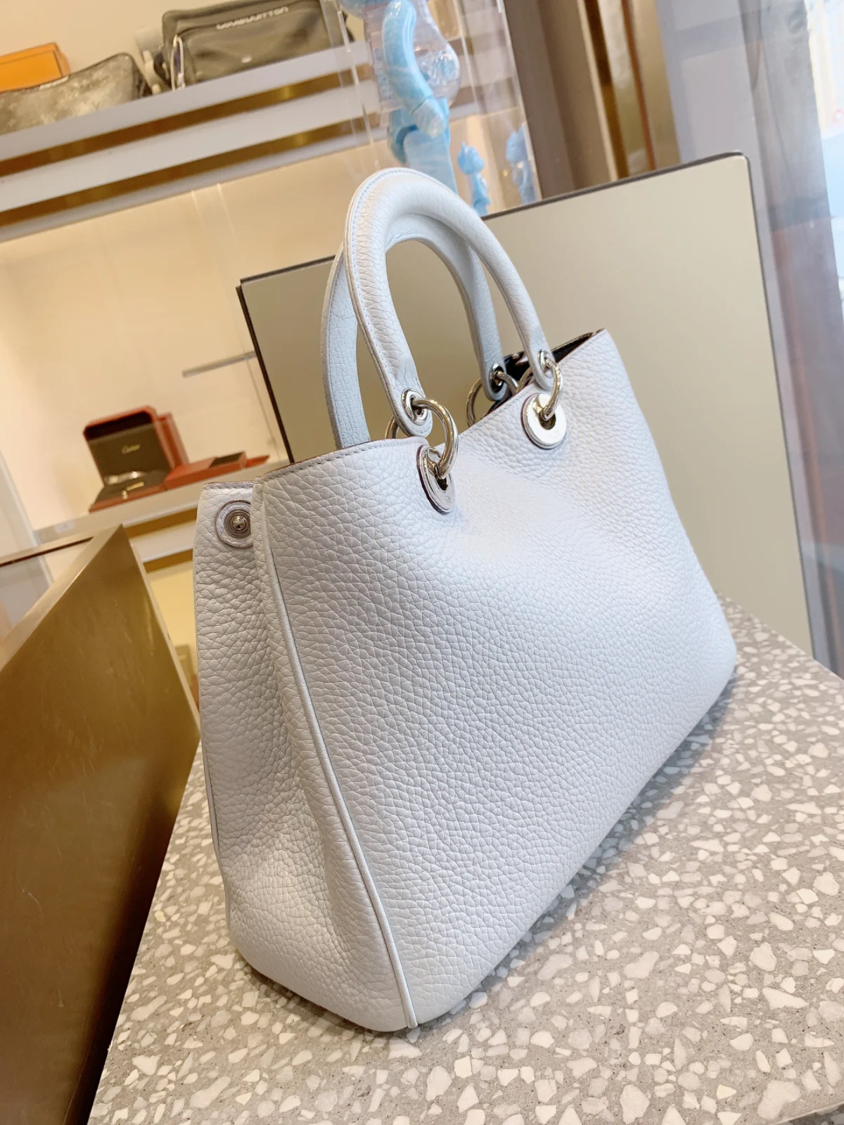 Pale blue pebbled leather tote with rounded handles and silver ring hardware